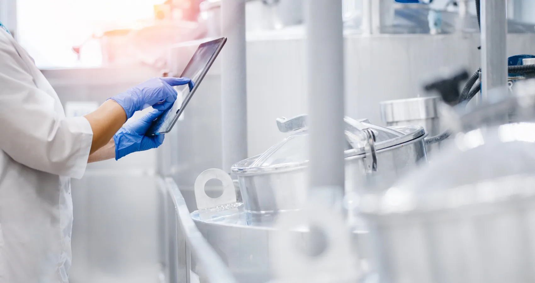 Concept food industry banner. Factory worker inspecting production line tanker in of dairy factory with computer tablet